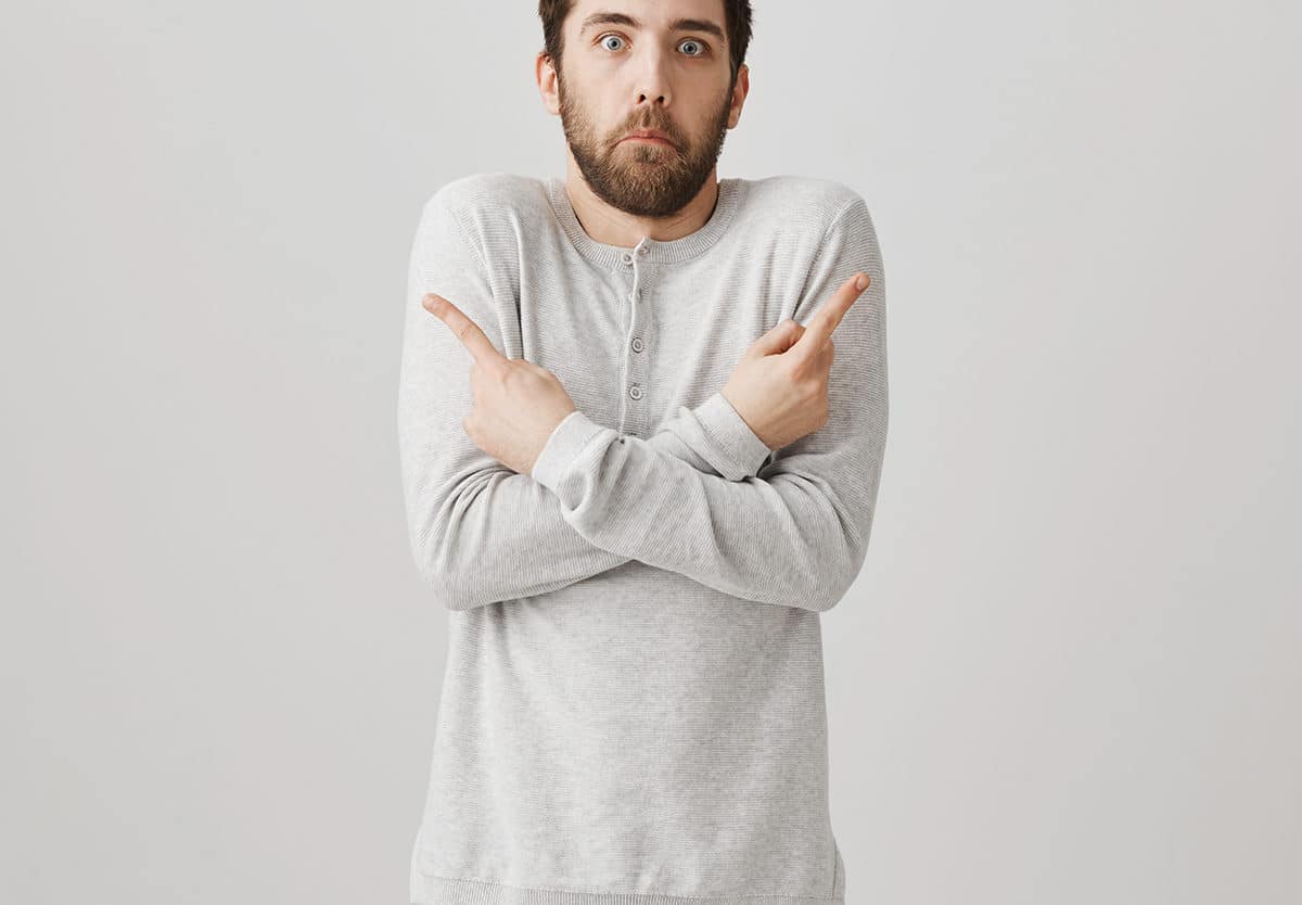 person pointing fingers to either direction showing that he does not know who to blame