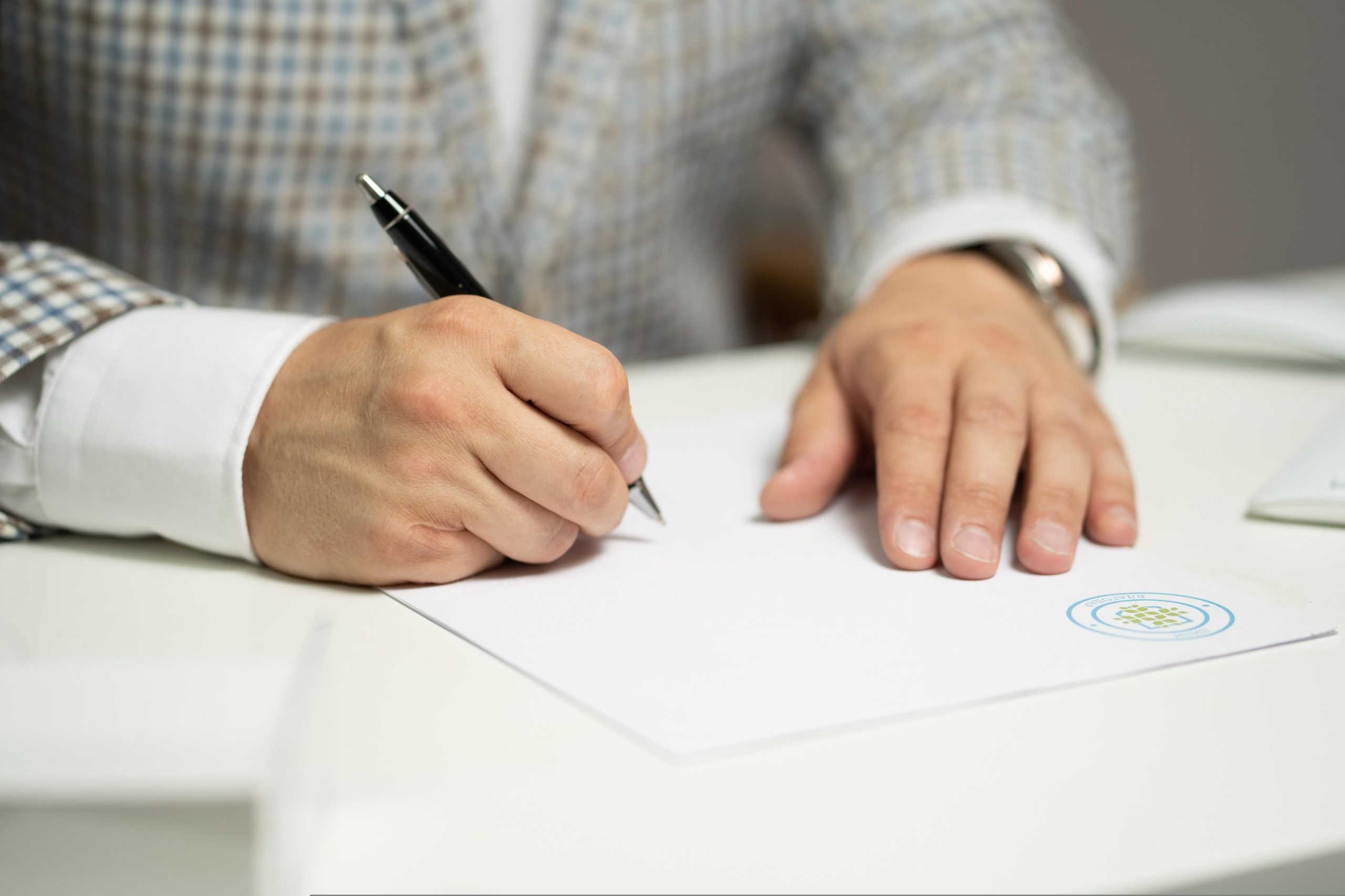 man signing documents on his desk